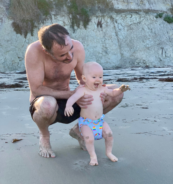 baby with dad at the beach in a cloth diaper